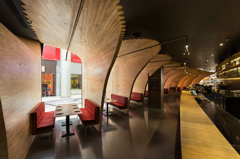Sculptural wood elements flow from the exterior to the interior of this restaurant