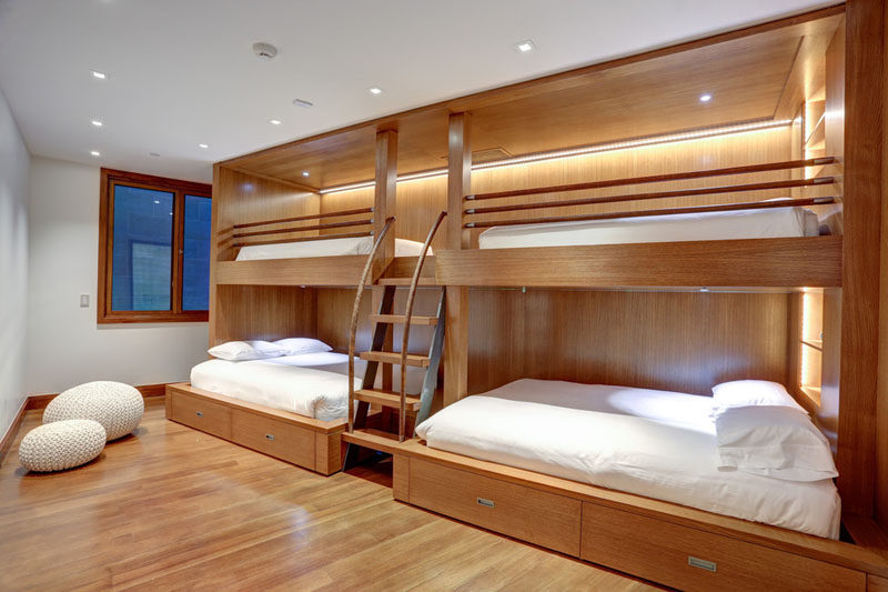Interior Design Ideas For Sleeping Six People In A Room // Zone 4 Architects designed this wooden bunk bed unit with hidden lighting and storage, that has two larger beds located below the two upper bunks, making it an ideal place to sleep six.