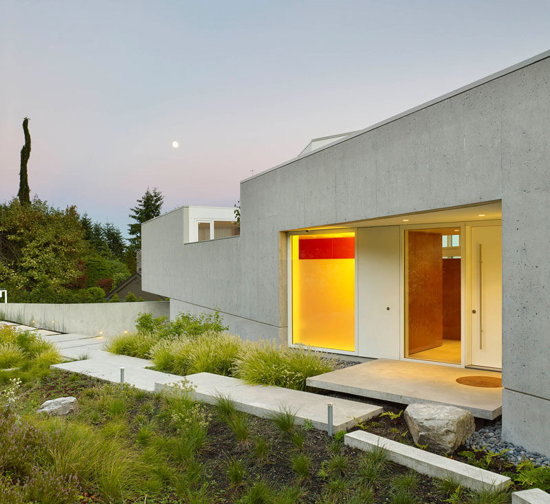 A concrete path surrounded by landscaping, guides you to the front door.