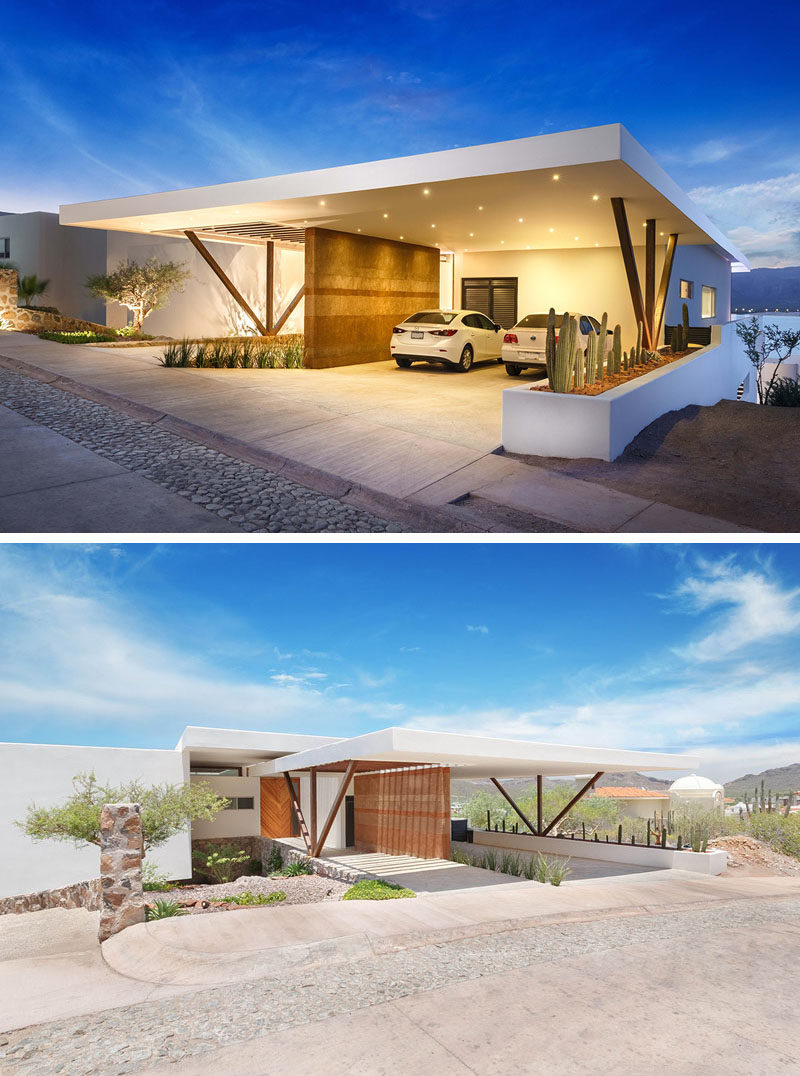 This home has a covered carport with a rammed earth feature wall, that is also brightly lit at night.
