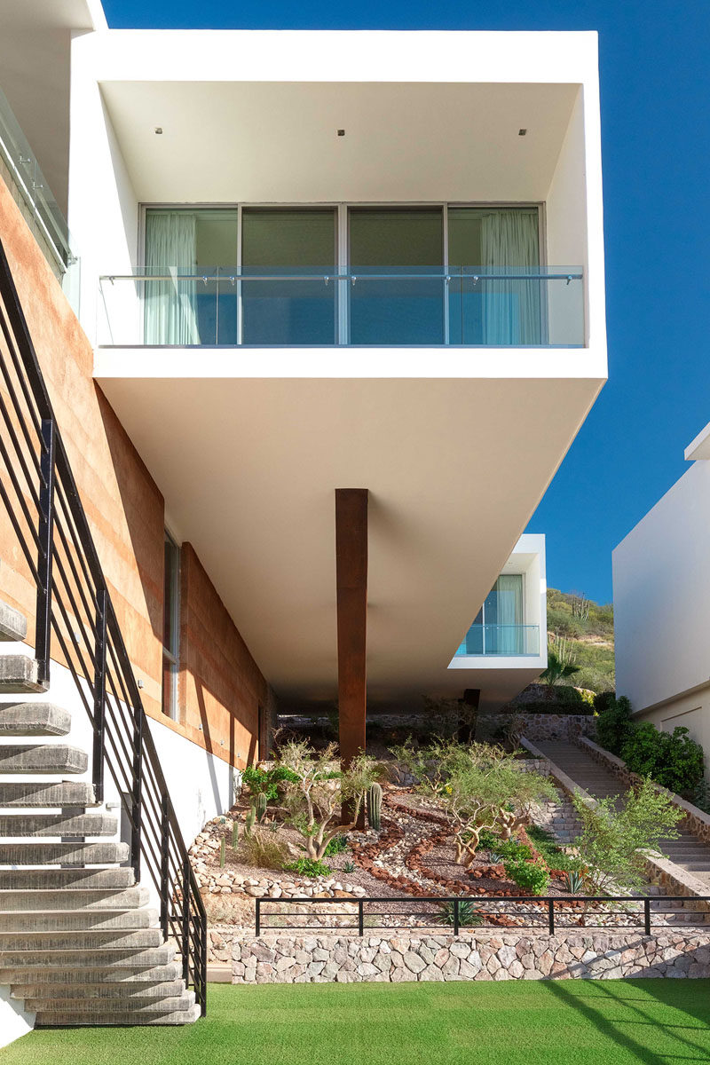 Creative landscaping has been used to liven up a void under this overhanging section of a house.