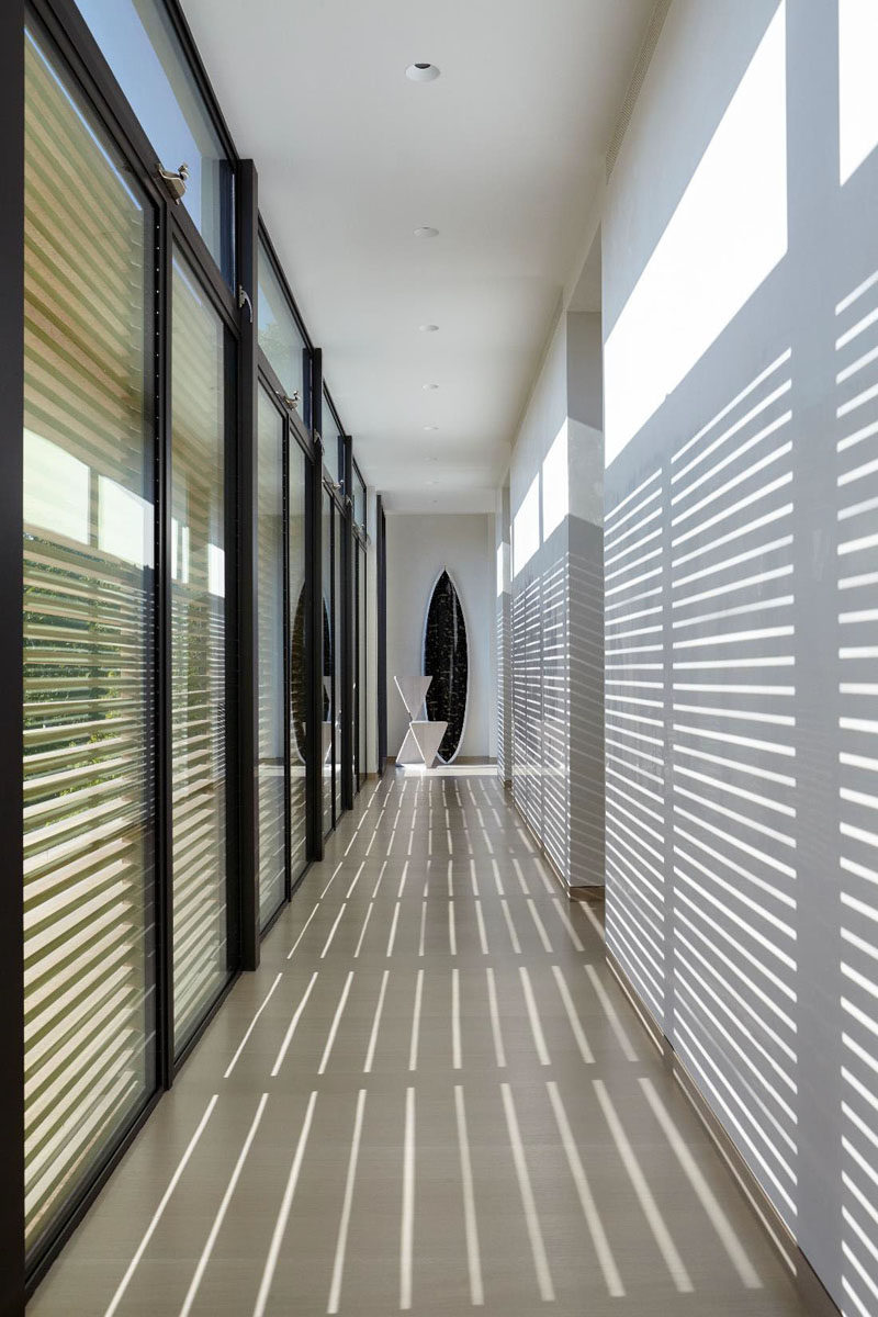 A wall of windows provides light to the hallway, but can also be shaded when needed.