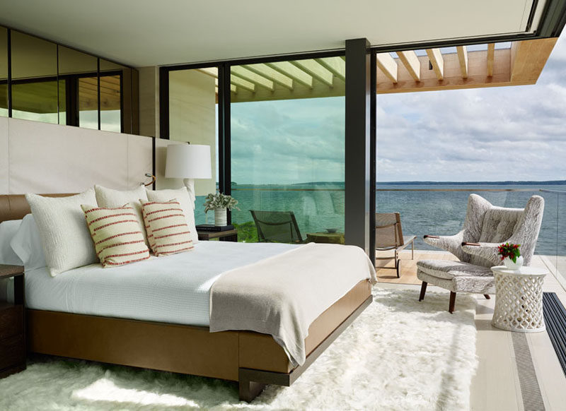 This bedroom opens up to a balcony with lounge chairs and water views.