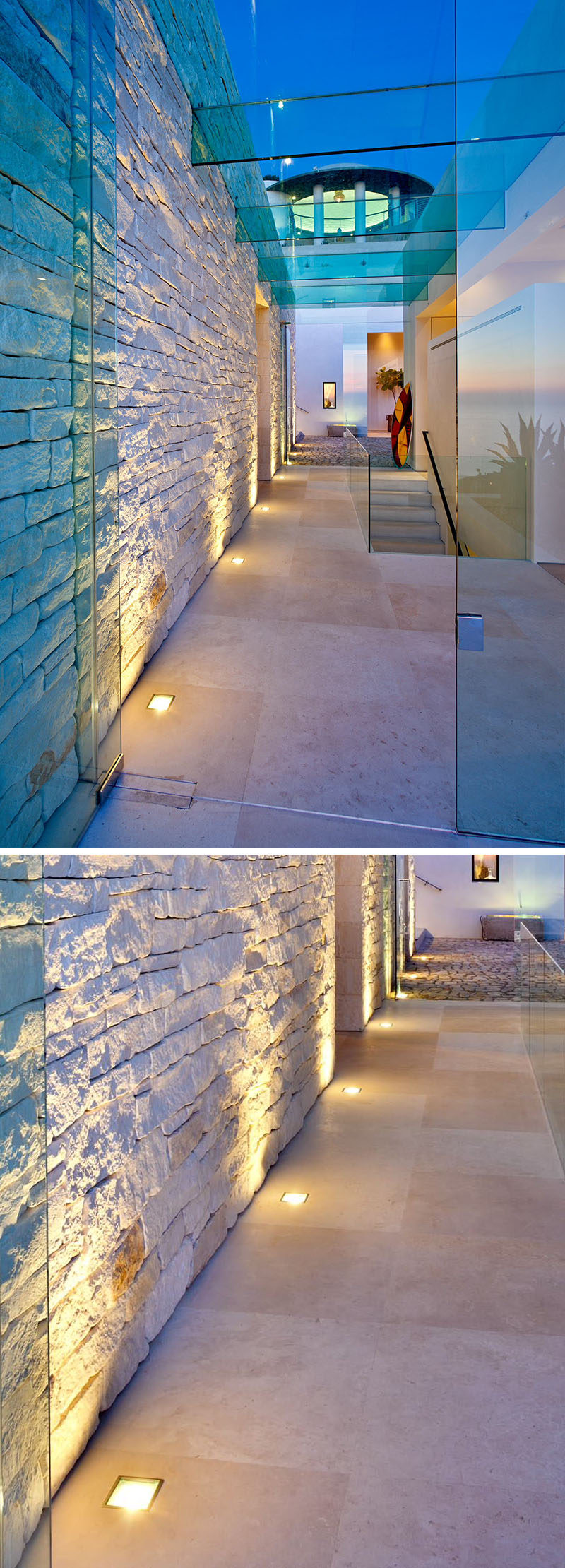 7 Interiors That Use Dramatic Uplighting To Brighten A Space // Warm lights run along the bottom of the entry way wall and highlight the texture of the stones used in the wall.