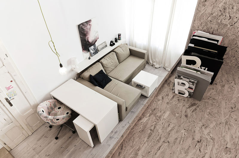 This living area in a small apartment, has a sofa for relaxing and a desk for working.