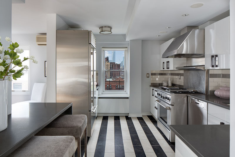 7 Examples Of Striped Floors In Contemporary Homes // Shiny stainless steel coupled with the worn in striped tile floor make this apartment feel modern yet cozy and sophisticated.