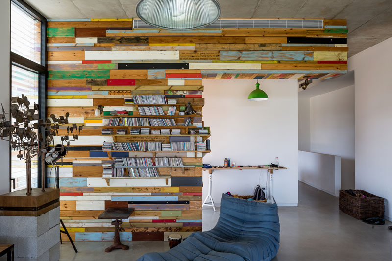 This scrap wood feature wall makes an artistic statement and hides a bookshelf.