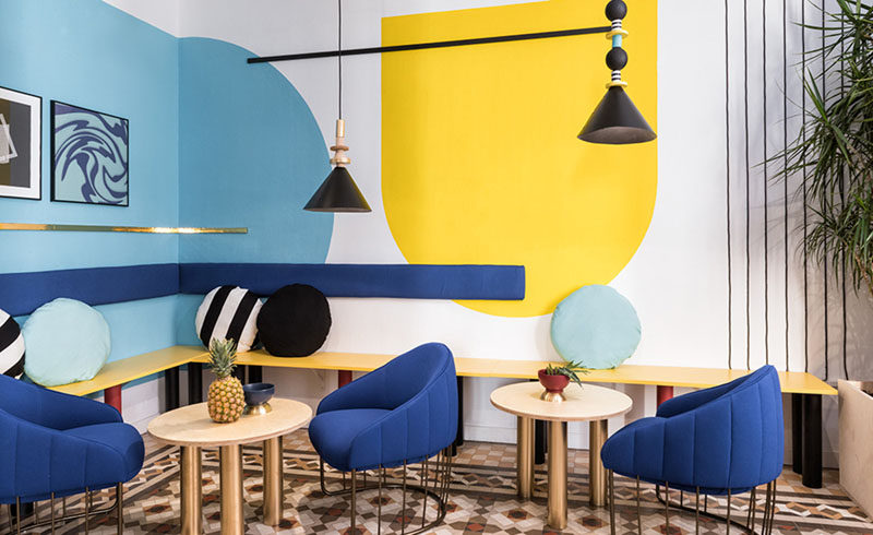 Wall Decor Inspiration - Bold Graphics Cover The Walls Of This Spanish Hostel // A pop of yellow on the wall and the seat of the bench breaks up the blue and black.