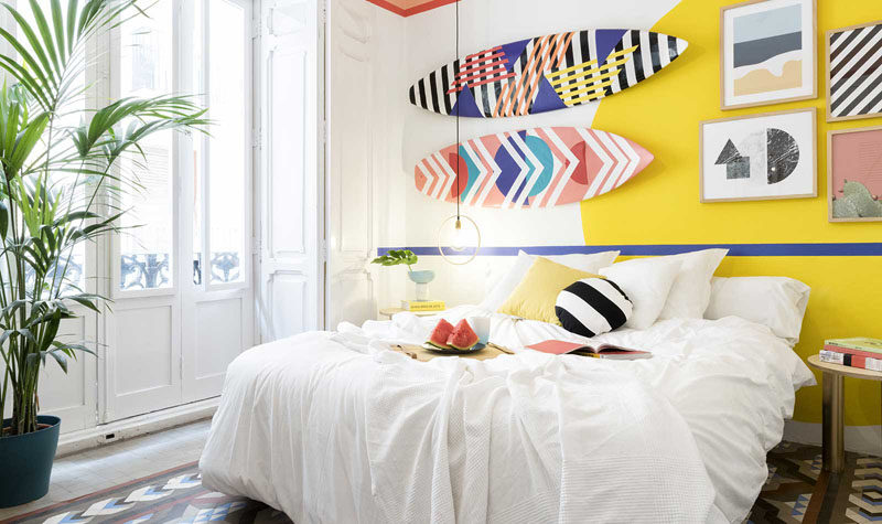 Wall Decor Inspiration - Bold Graphics Cover The Walls Of This Spanish Hostel // Fun graphics on surfboards that hang as art, add to the playfulness of this room.