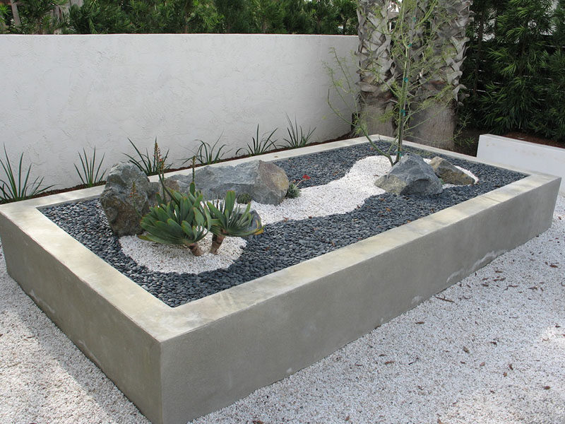 10 Inspirational Ideas For Including Custom Concrete Planters In Your Yard // This large concrete planter full of rocks, pebbles, and plants, puts a spin on the traditional zen garden.