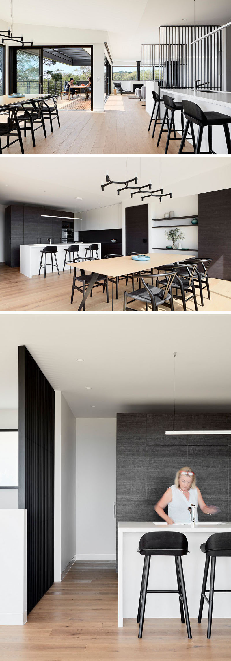 Beside the living area in this home is the indoor dining area and kitchen. In the dining room, the black chandelier matches the black chairs, while in the kitchen, a bright white kitchen island is a strong contrast against the dark wood cabinetry.