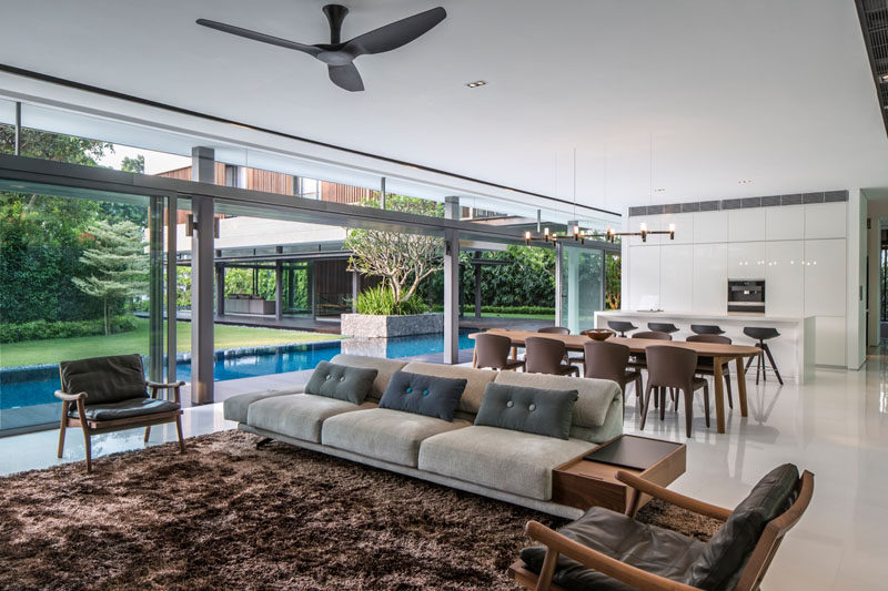 In this open-plan Singaporean home the living , dining and kitchen areas all open up to the pool and garden outside.