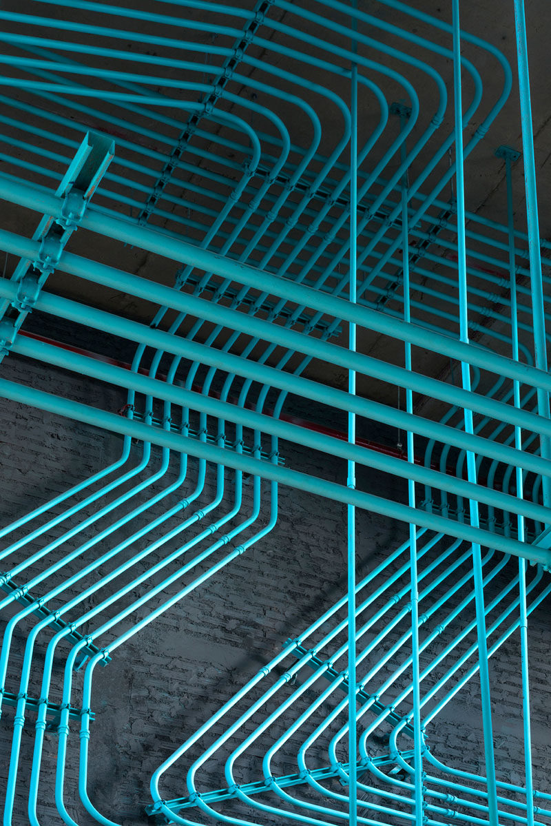 Turquoise electrical conduit is a design feature running through this