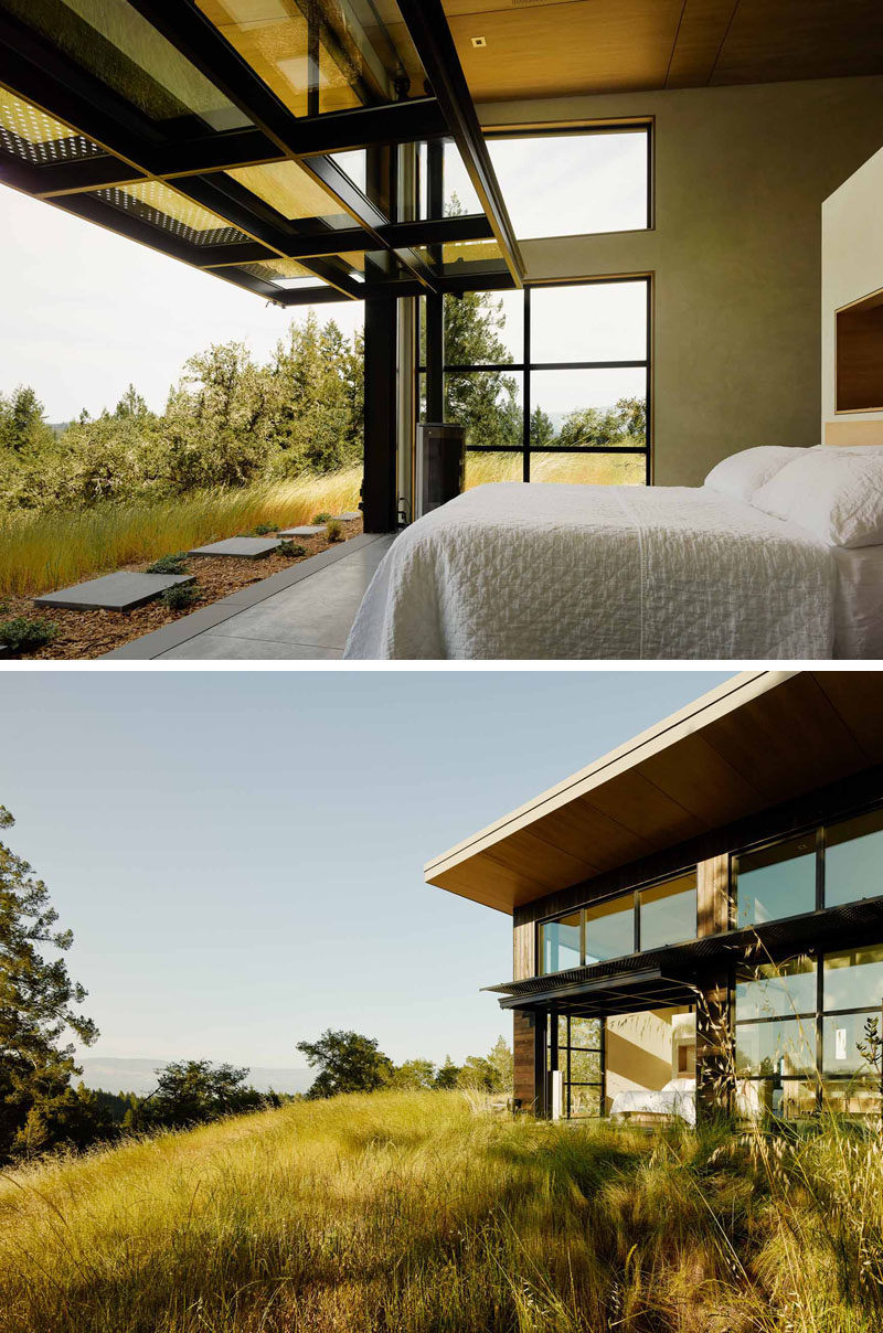 This bedroom opens up to the outdoors via a large glass paneled door on a pulley system.