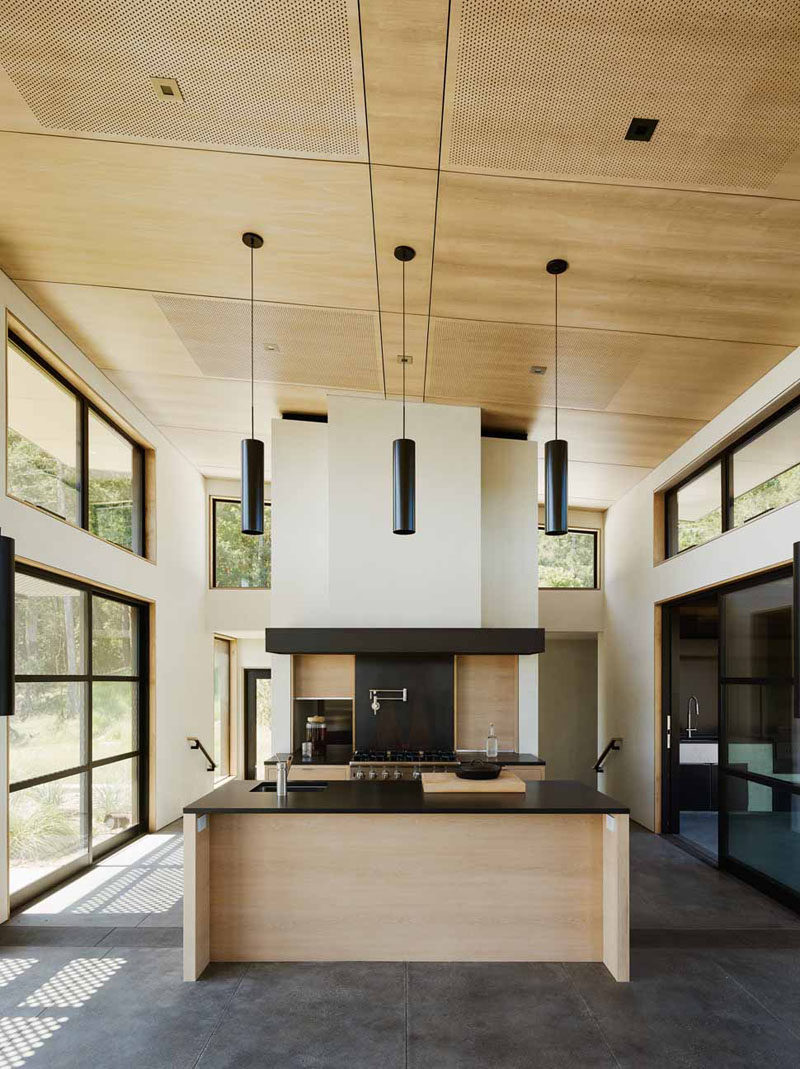 High ceilings and lots of windows let plenty of light into this wooden kitchen. Black accents match the window and door frames surrounding the kitchen.