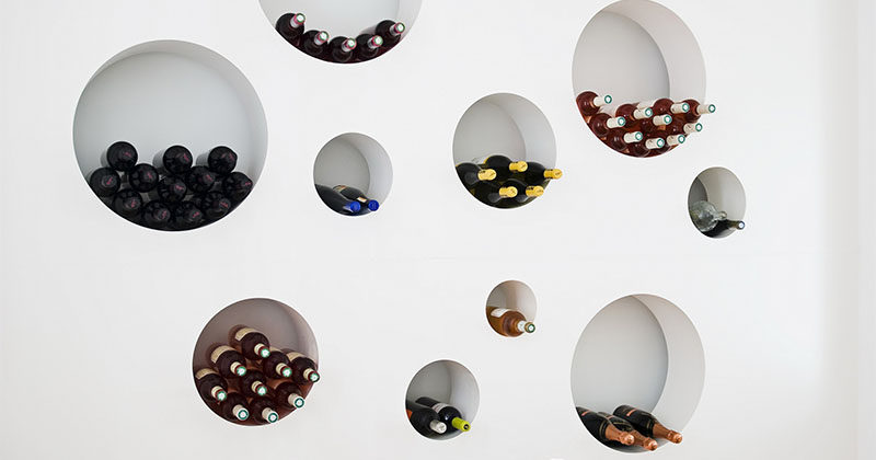 Wine Storage Idea ? This wall of circular cut-outs is a creative way to rack up the bottles