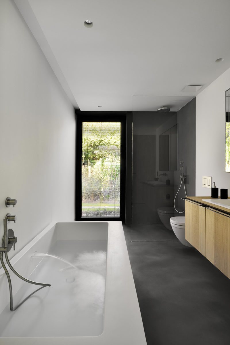This modern guest bathroom has a gray, white and wood palette.