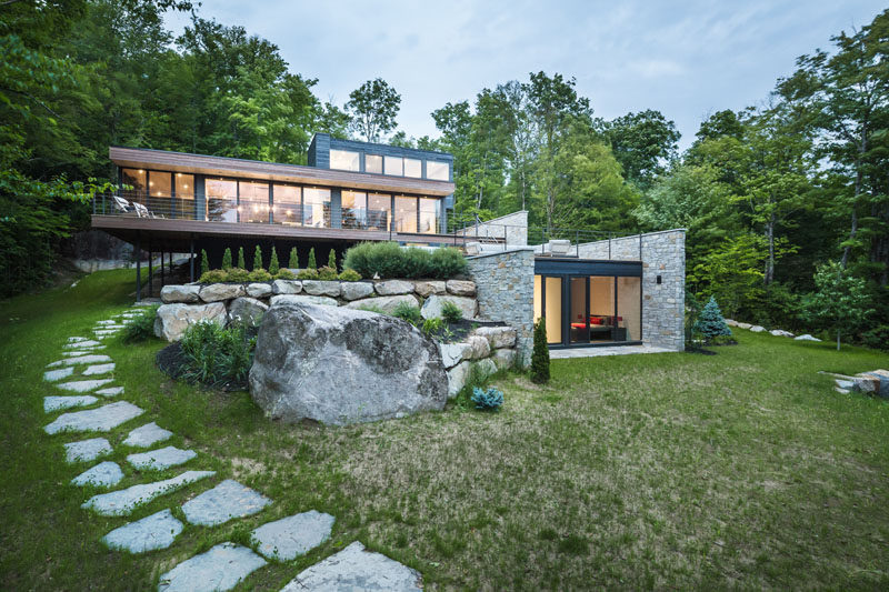 Wood And Stone Cover The Exterior Of This Multi-Level Modern House In The Forest