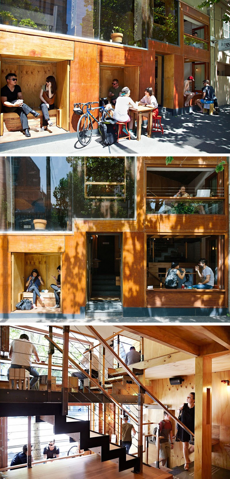 This modern cafe has built-in wooden seating nooks on the outside of the cafe, while inside, people sit at bars looking out onto the street.