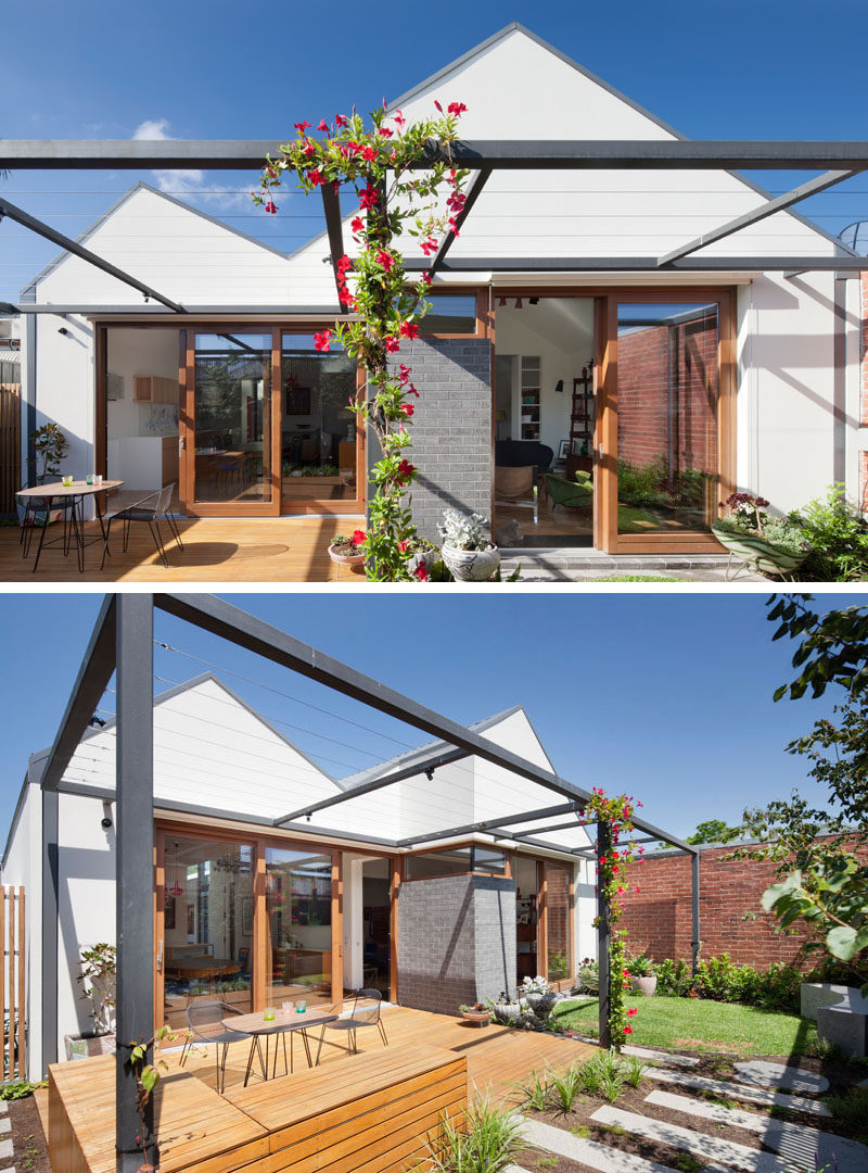 In the backyard of this modern house, a sunny dining patio sits under a pergola that will one day be covered in plants to provide shelter from the sun. A circular grassy seating area and a small garden on the other side of the yard are just off of the formal living room and provide a more casual spot to sit and enjoy the day.