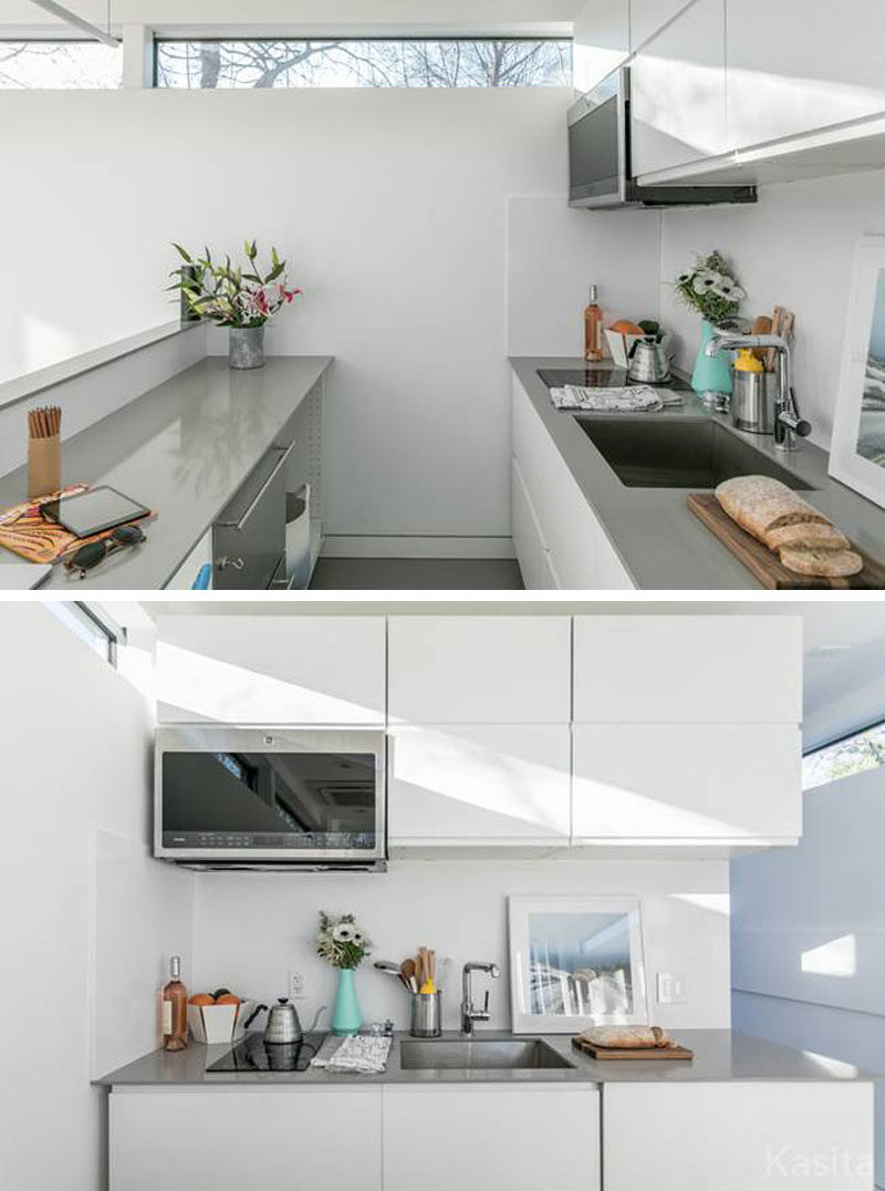 This small white and grey kitchen has a two burner induction cooktop and a convection microwave oven, as well as more storage and two counter spaces. 