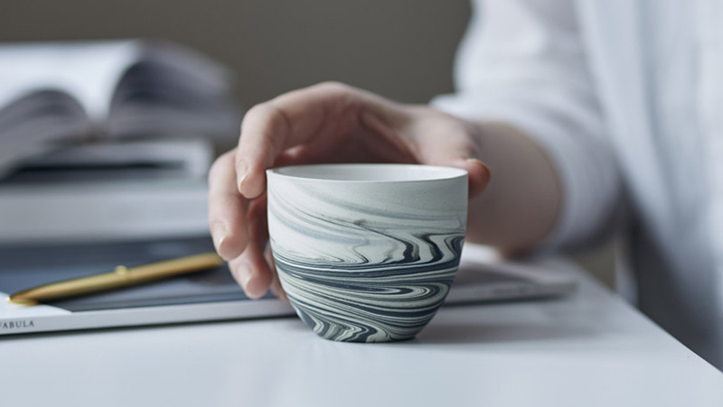 This modern ceramic espresso cup has a matte grey black swirl pattern. 