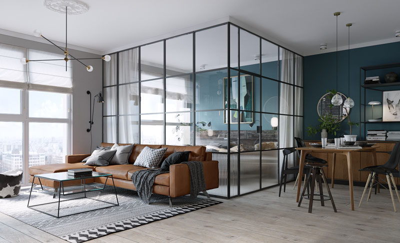 This small and modern apartment features bedroom in a black framed glass box with a deep teal accent wall.