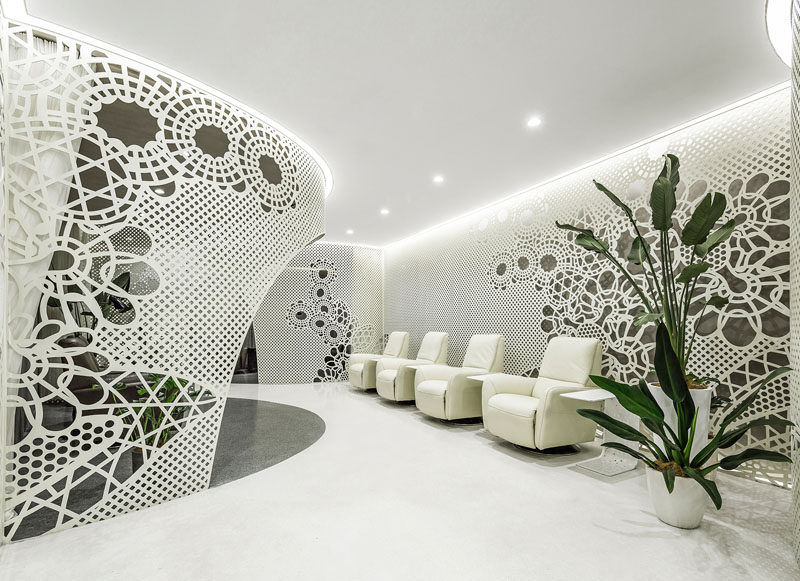 ARCHSTUDIO have designed a modern nail salon that features a dark steel plate exterior and a bright white interior full of lace-like patterns on the walls.