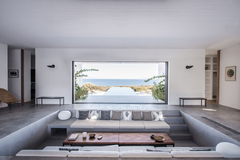 This modern summer house in Greece has a sunken living room with built-in furniture, that allows for uninterrupted views throughout the house. #SunkenLivingRoom #LivingRoom #InteriorDesign #ModernHouse