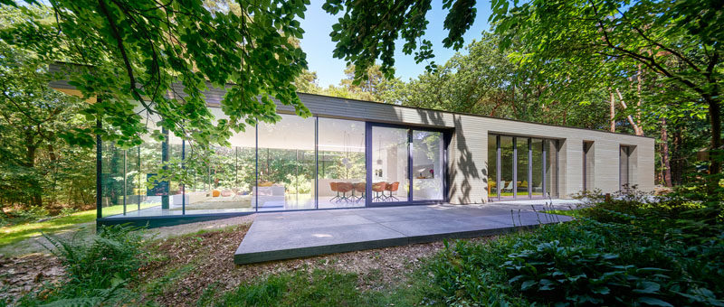 This modern villa has one end completely surrounded by glass that allows the living room to out onto the garden. #ModernHouse #HouseDesign #Architecture