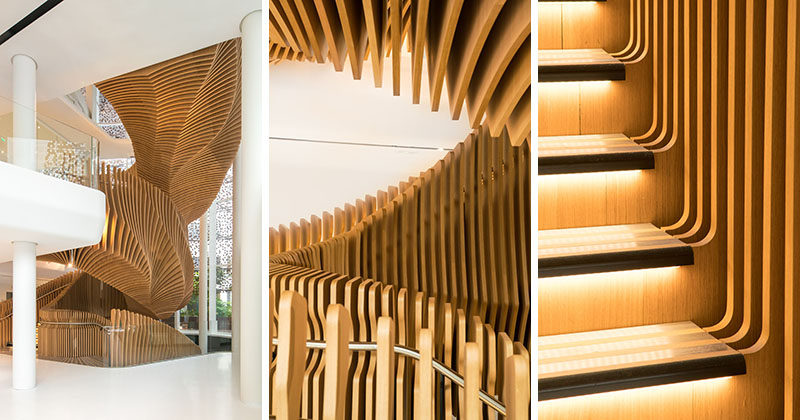 This large, sculptural, snake-like, wood staircase was installed in a new office building in France to connect the four floors of the building. #WoodStairs #SculpturalStairs #StairDesign #OfficeDesign #Stairs
