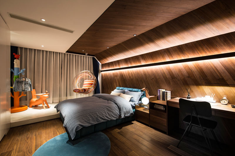 This modern kids bedroom features unique wrap-around wood accent wall with hidden lighting, that continues onto the ceiling. #AccentWall #ModernBedroom #WoodHeadboard