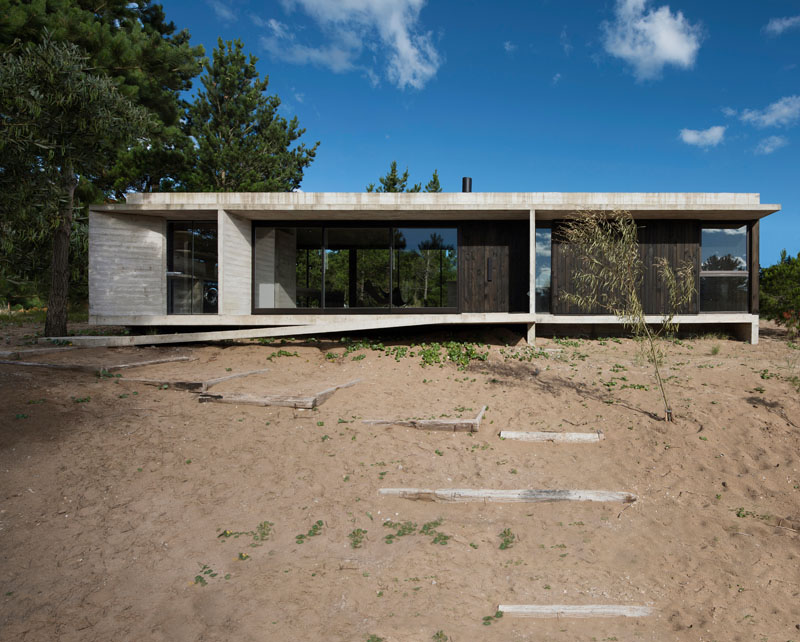 Architect Luciano Kruk has designed a new single storey concrete and wood house in Costa Esmeralda, Buenos Aires, for their clients, a couple with kids. #Concrete #Wood #ModernHouse