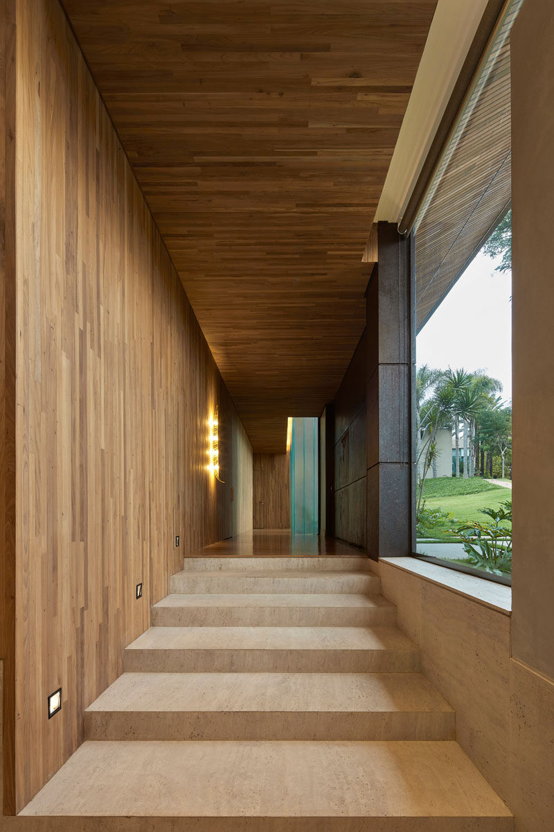 Just inside the front door of this modern house is a hallway that's covered in wood, and that leads to the different levels of the house. #Hallway #Entryway