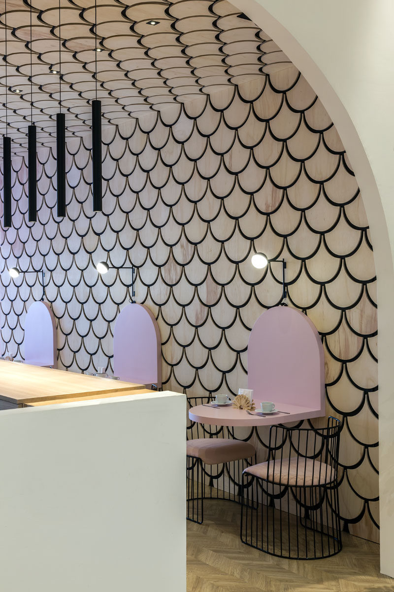 This modern patisserie features a scalloped or fish scale patterned wood accent wall. #ModernPatisserie #CafeDesign #InteriorDesign #Cafe #AccentWall