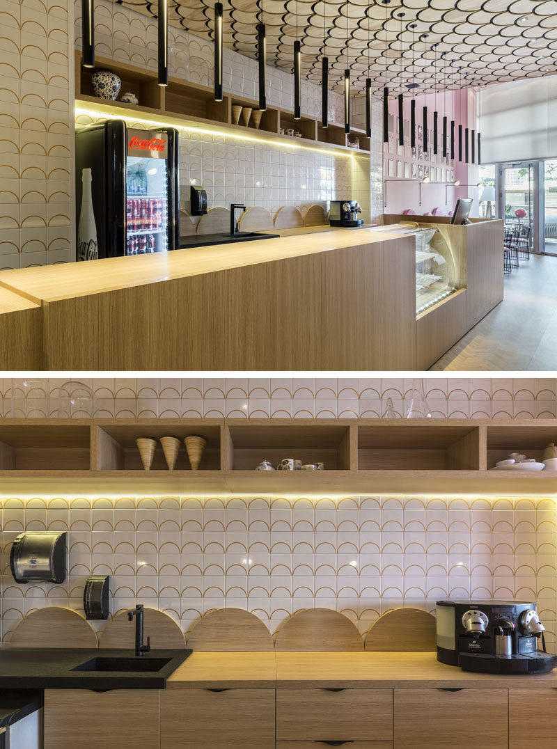 In this modern patisserie, hidden lighting under the mounted wall shelf and a line of individual pendant lights above the service area, help to keep the space bright. #ModernCafe #ModernPatisserie #InteriorDesign