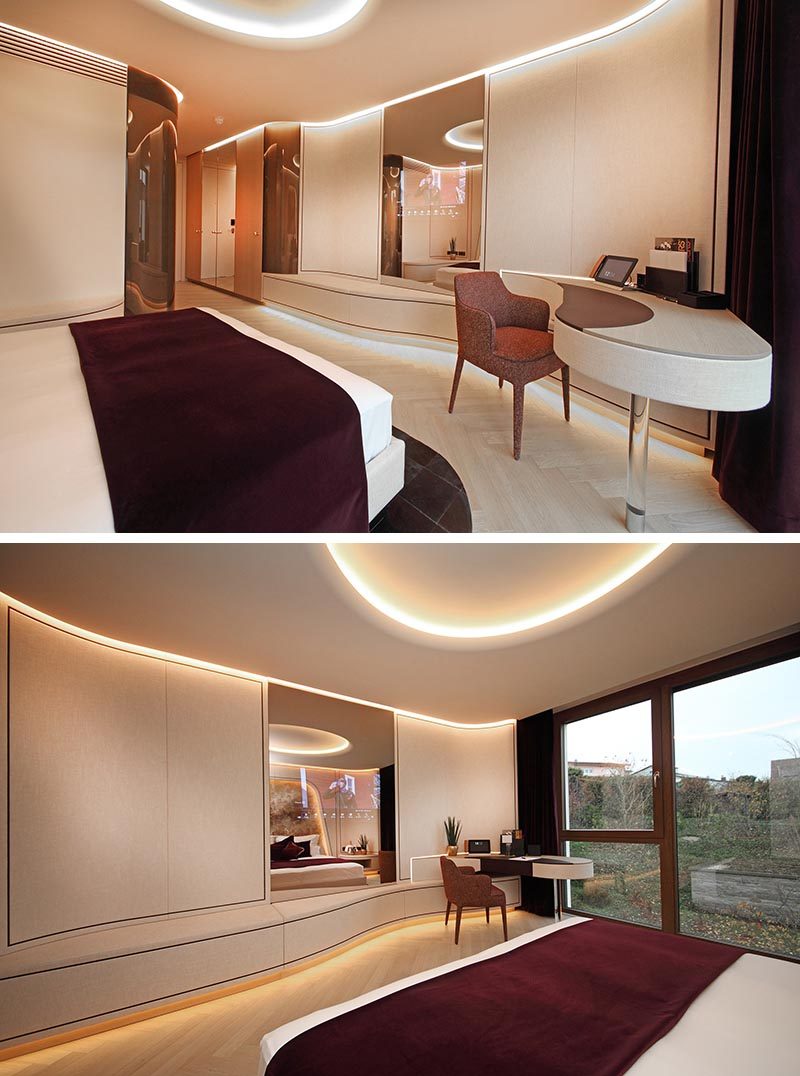 Flowing design elements, like the desk in this modern hotel room, create a soft and curvaceous line that guides the eye towards the window. #BuiltInDesk #HotelRoom #InteriorDesign