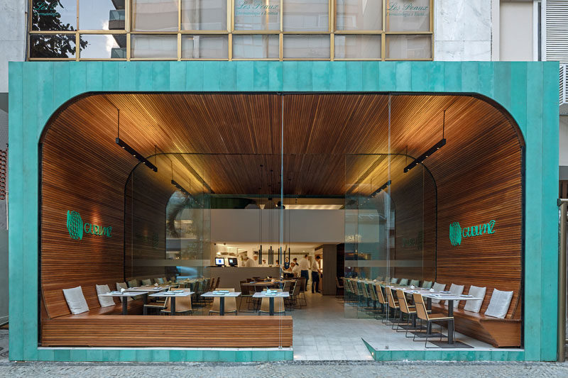 Bernardes Arquitetura have designed Gurumê, an open and modern Japanese restaurant, that features a 'tunnel' of wood slats and a facade of oxidized copper. #RestaurantDesign #ModernRestaurant #InteriorDesign