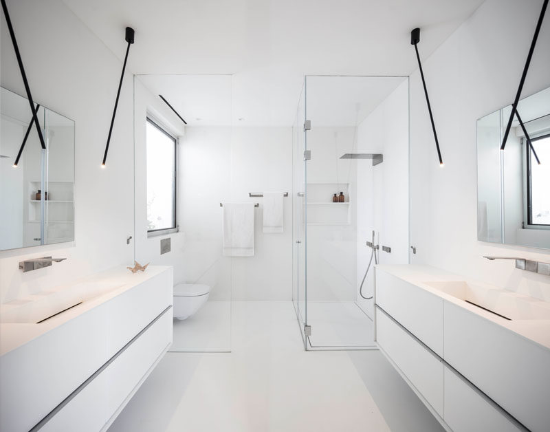 This modern master bathroom is bright white, with minimalist black lighting, and a floor-to-ceiling glass shower screen. #ModernBathroom #WhiteBathroom