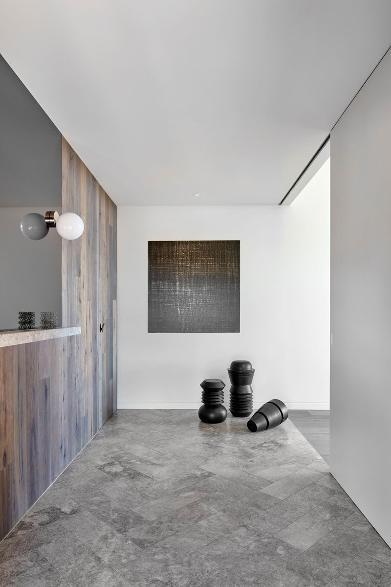 The entryway of this modern house features flooring laid in a herringbone pattern. #ModernEntryway #HerringbonePattern #Flooring