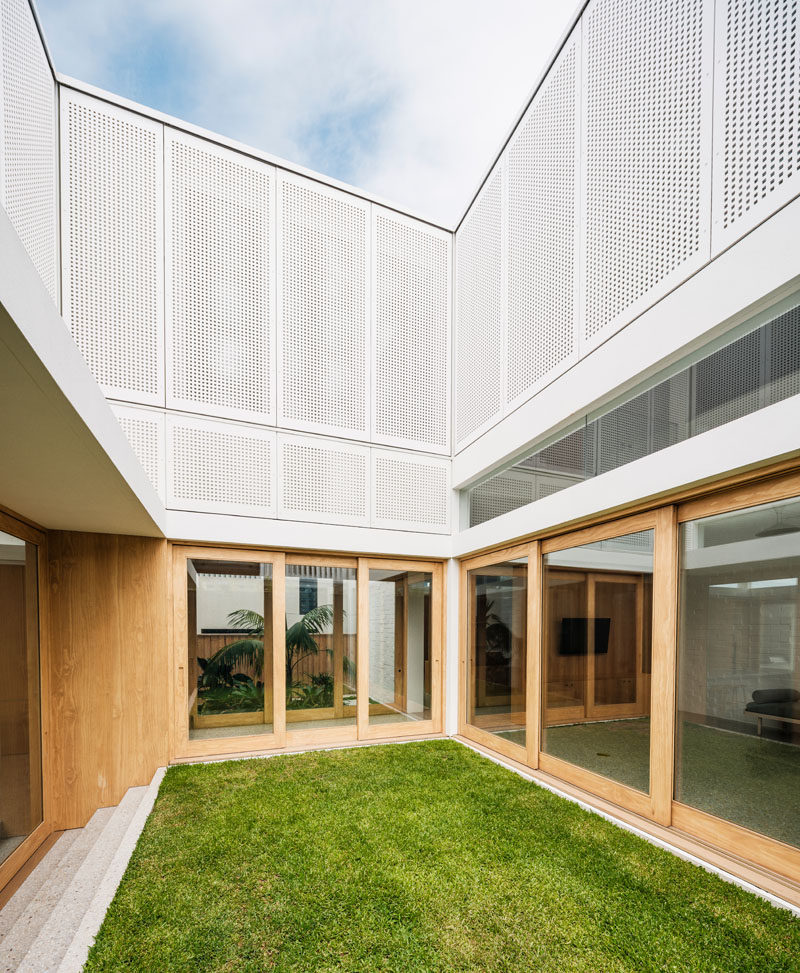 The interiors of this modern house opens up to an internal grassy courtyard. #Courtyard #ModernArchitecture