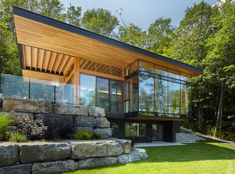 A new modern cottage with a cantilevered roof, and a landscaped section with lounge areas, were added to an existing smaller cottage. #ModernArchitecture #Landscaping #ModernCottage #CantileveredRoof