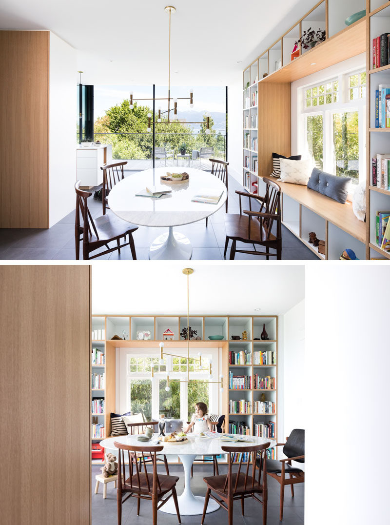 This contemporary dining area has a built-in window seat that's surrounded by open shelving. #WindowSeat #DiningRoom