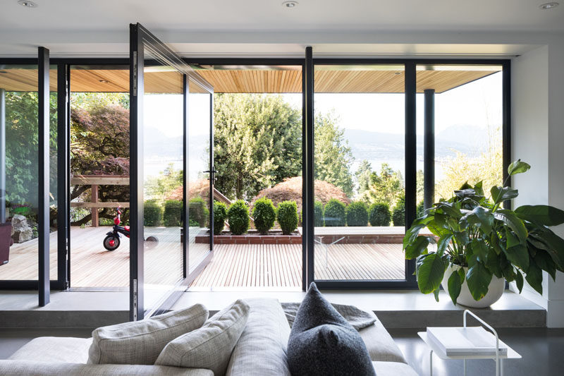 This modern family room has a large glass pivot door to create a direct connection to the outdoor garden. #PivotDoor #PivotingDoor #GlassDoor