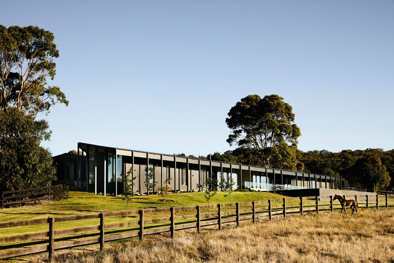 This modern farmhouse features three elongated pavilions that form a U shape, while the exterior has been clad in blackened timber, giving the home a monochromatic appearance. #ModernHouse #ModernArchitecture #HouseDesign
