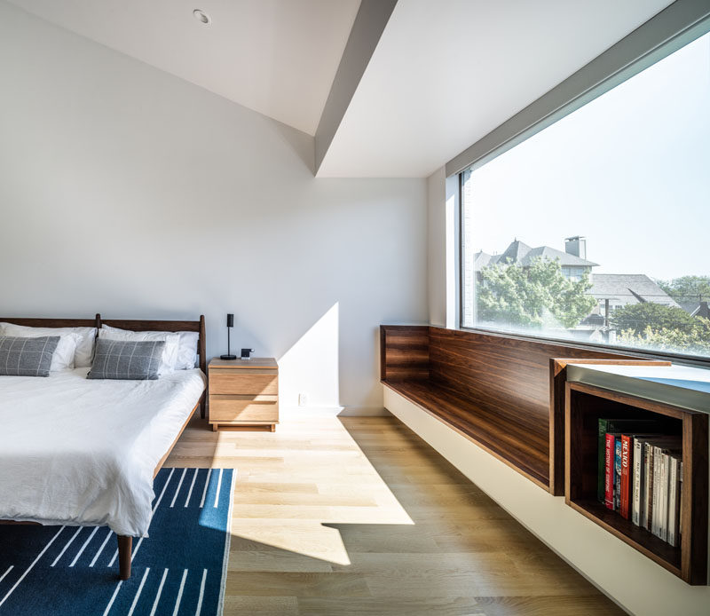 As part of a modern residential interior renovation, architect and interior design firm OFFICIAL, included a wood-lined built-in window seat and bookshelf in the master bedroom. #WindowSeat #Bookshelf #MasterBedroom