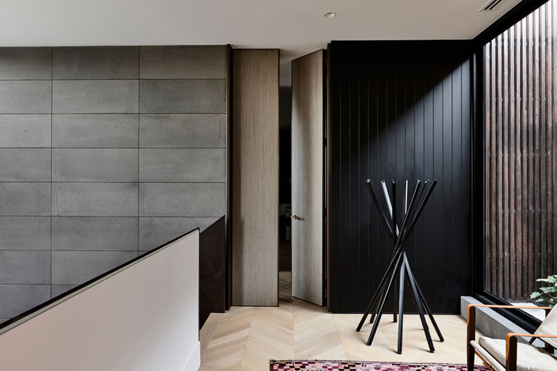 At the top of the stairs in this modern house, wood doors open to reveal the bedrooms, while large windows provide a glimpse of the garden outside. #ModernInteriorDeisgn