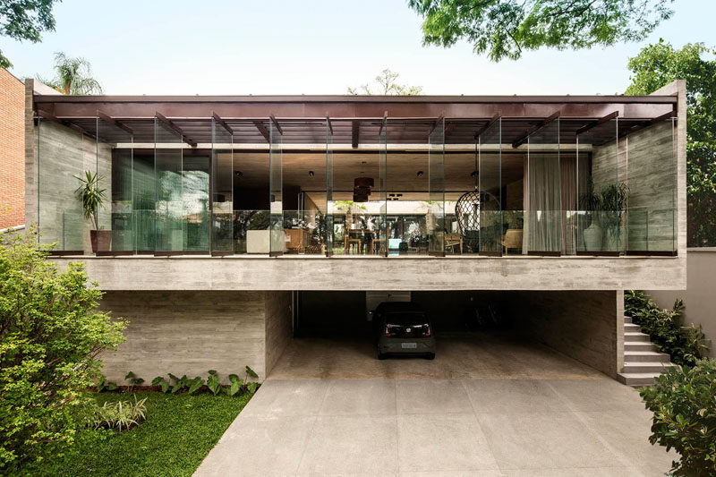 Drucker Architecture have recently completed a modern concrete house in Cidade Jardim, Brazil, that sits on a slope, and wraps around a grassy courtyard and a swimming pool. #Architecture #ConcreteHouse #ModernHouse