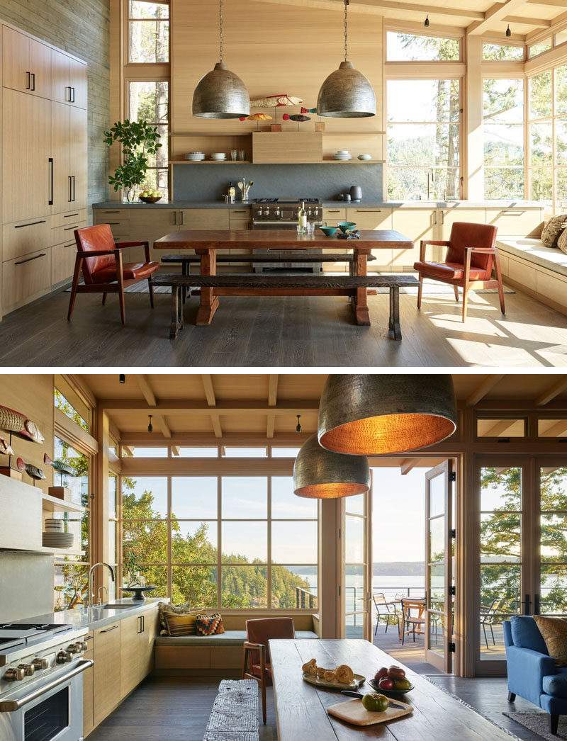 Light wood, a sloped ceiling, and plenty of windows, ensure that this kitchen is bright and welcoming. There's a built-in window seat for taking in the views, while doors connect the interior with the deck. #KitchenDesign #WindowSeat #WoodKitchen #Windows