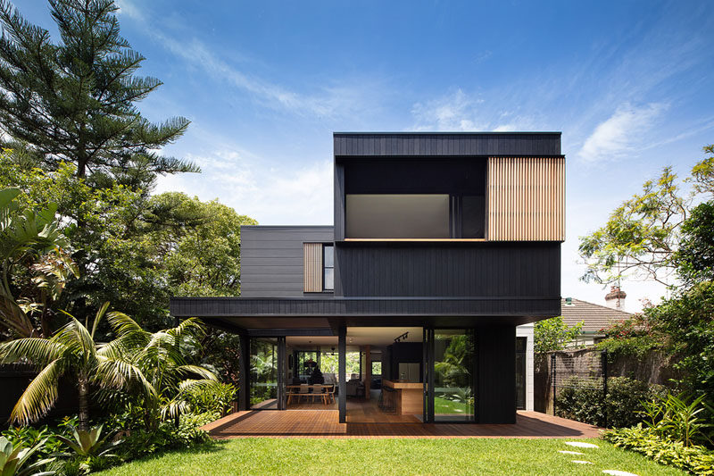The exterior of this modern house is clad in Blackened Cambia Ash and Scyon Stria, while sliding glass doors open the home up to the backyard. #ModernHouse #ModernArchitecture